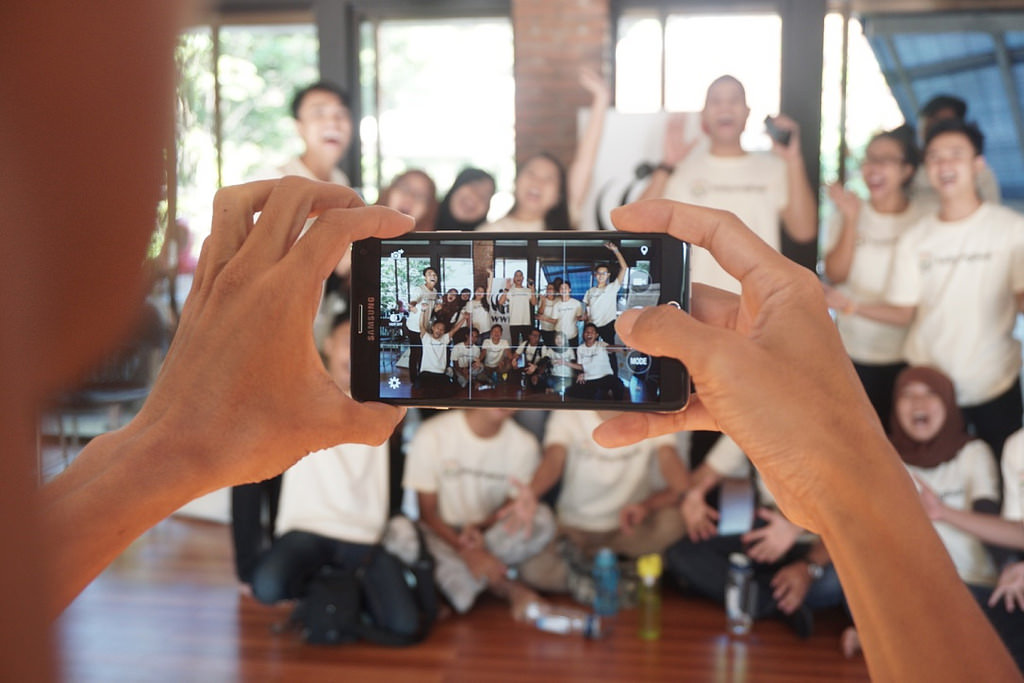 Digital citizens and citizen journalism are an important evolution in Indonesian citizenship. (Anton Muhajir) A group of people pose smiling for someone taking a photo on their phone.